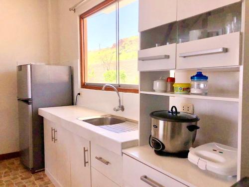 a small kitchen with a sink and a refrigerator at Casuarinas del Mar Chalet Playa Caballito de Mar in Canoas De Punta Sal