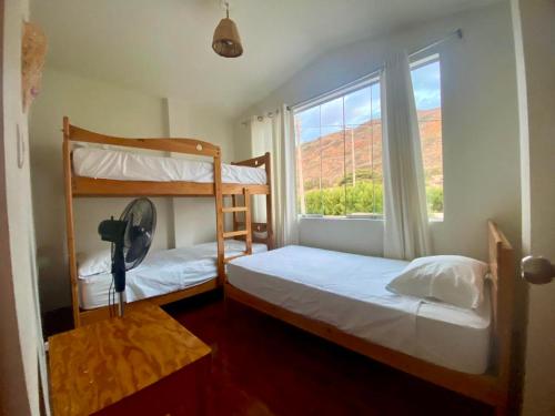 a bedroom with two bunk beds and a window at Casuarinas del Mar Chalet Playa Caballito de Mar in Canoas De Punta Sal