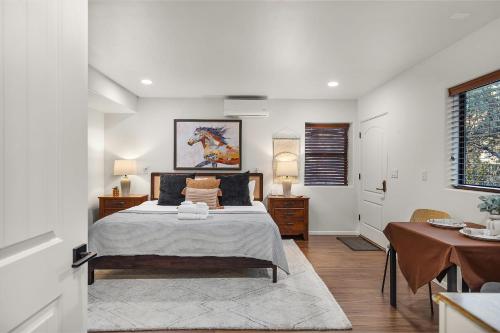 a white bedroom with a bed and a table at Mammoth Rock Oasis Villa-Hot Tub & Free Pets in Sedona