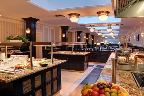a restaurant with a buffet line with fruits on display at Luxury Spa Hotel Olympic Palace in Karlovy Vary
