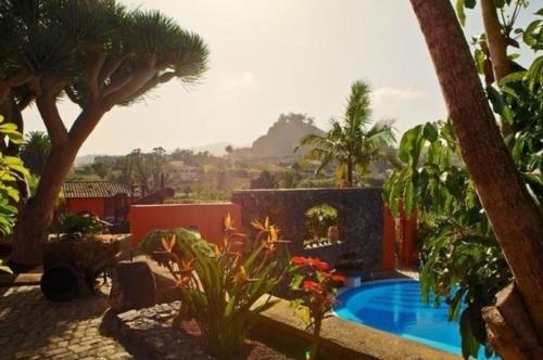 una villa con piscina e palme di Ferienhaus in La Caridad mit Terrasse, Grill und Whirlpool a Adelantado