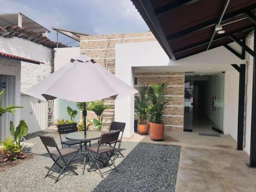 d'une terrasse avec une table et un parasol blanc. dans l'établissement Hotel Melao, à Palmira