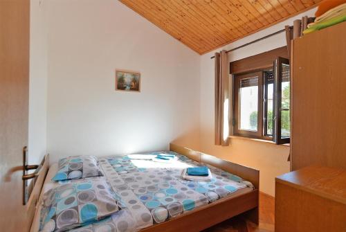 uma pequena cama num quarto com uma janela em Ferienwohnung für 4 Personen ca 50 qm in Peroj, Istrien Istrische Riviera em Peroj