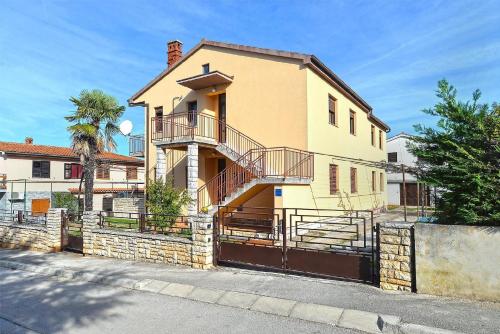 uma casa amarela com uma varanda numa rua em Ferienwohnung für 4 Personen ca 50 qm in Peroj, Istrien Istrische Riviera em Peroj