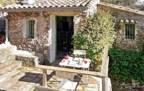 une table et des chaises devant une maison en pierre dans l'établissement La Baume, à Saint-Bresson
