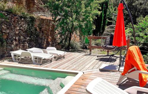 une terrasse avec une piscine, des chaises et un parasol dans l'établissement La Baume, à Saint-Bresson