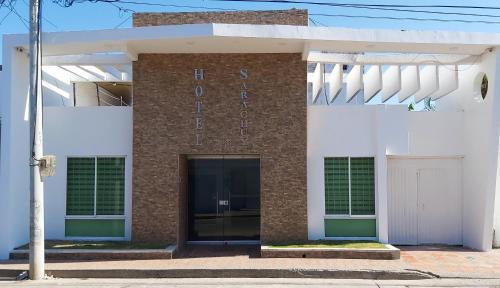 un bâtiment en briques blanches et rouges avec une porte dans l'établissement HOTEL SARACHUY VALLEDUPAR, à Valledupar