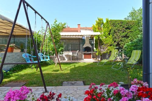 un jardín con un columpio y flores en el patio en Ferienwohnung für 4 Personen ca 50 qm in Fažana, Istrien Istrische Riviera en Fažana