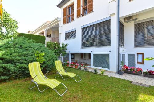 dos sillas verdes en el patio de una casa en Ferienwohnung für 4 Personen ca 50 qm in Fažana, Istrien Istrische Riviera en Fažana