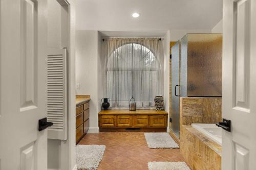 La salle de bains est pourvue d'un lavabo, d'une baignoire et d'une fenêtre. dans l'établissement Mammoth Rock Splendor Family Home-Close to town Huge Spa & Game Room, à Sedona