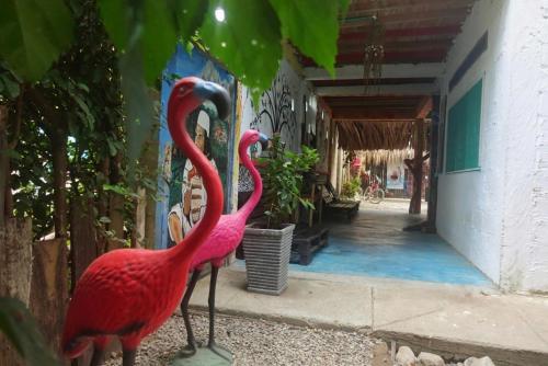 two pink flamingos standing outside of a building at Casa Surf Mar Azul in Palomino