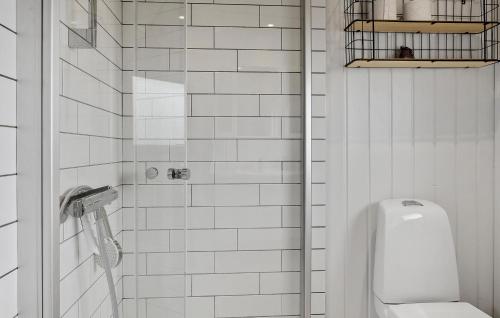 Baño de azulejos blancos con aseo y urinario en Stunning Home In Juelsminde With Wifi, en Sønderby