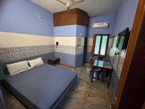 Habitación con cama y mesa. en AURO GUEST HOUSE en Auroville