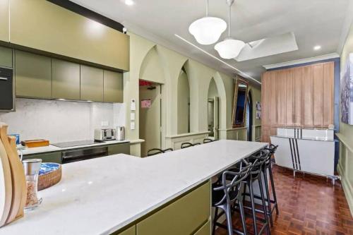 a large kitchen with a large white counter top at A Luxury Space with Playstation in Darling Harbour in Sydney