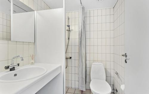 Baño blanco con aseo y lavamanos en Nice Apartment In Rudkbing With 2 Bedrooms And Wifi, en Rudkøbing