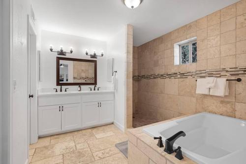 a large bathroom with a tub and a mirror at HUGE Golf course Family home-FREE Heated Pool-Theater-Gym in Tempe