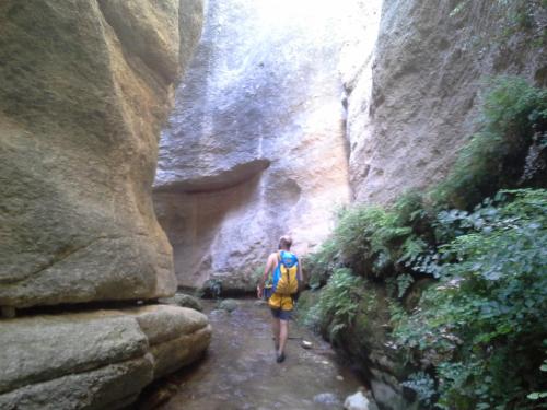 a person walking through a narrow slot canyon at Alojamiento Rural El Brazal in Lanjarón