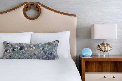 a bedroom with a bed and a table with a lamp at The Ritz-Carlton, Sarasota in Sarasota