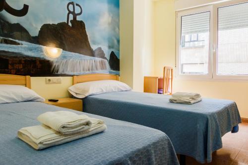 a bedroom with two beds with towels on them at Pension Teresa in Calahorra