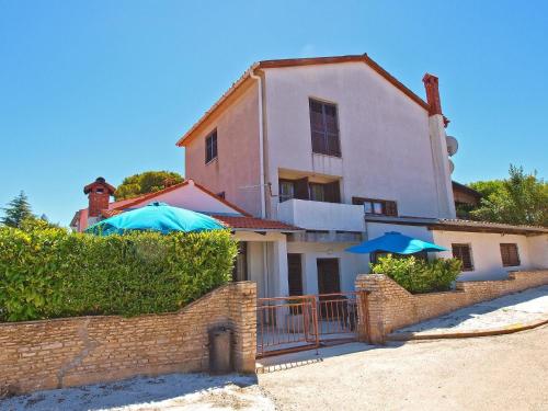 una casa con dos sombrillas azules delante de ella en Ferienwohnung für 4 Personen ca 56 qm in Stinjan, Istrien Istrische Riviera, en Štinjan