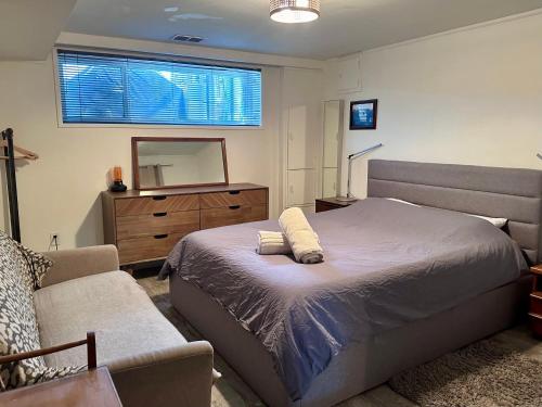 una camera con letto, cassettiera e specchio di The Orange Door Bungalow a Vancouver