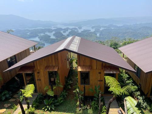 ein Holzgebäude mit einem Dach mit Bergen im Hintergrund in der Unterkunft Cái Gùi Tà Đùng in Biđong
