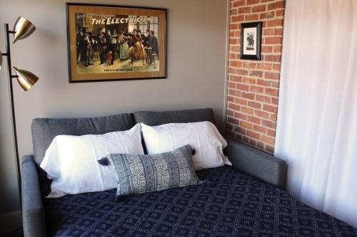 a couch with pillows and a movie poster on the wall at The Owl House in Galena