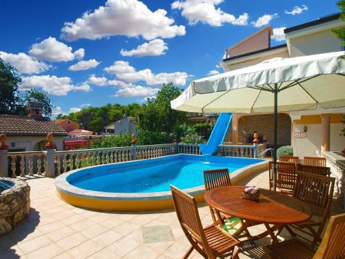 a pool with a slide and a table and chairs at Ferienwohnung für 4 Personen ca 55 qm in Ližnjan, Istrien Südküste von Istrien in Ližnjan
