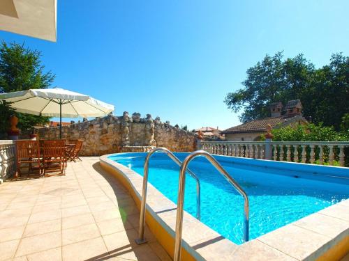 a swimming pool with a table and an umbrella at Ferienwohnung für 4 Personen ca 55 qm in Ližnjan, Istrien Südküste von Istrien in Ližnjan