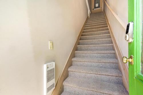 a stairwell with a green door and a staircase with stairs at The Avonlea Inn in Stratford