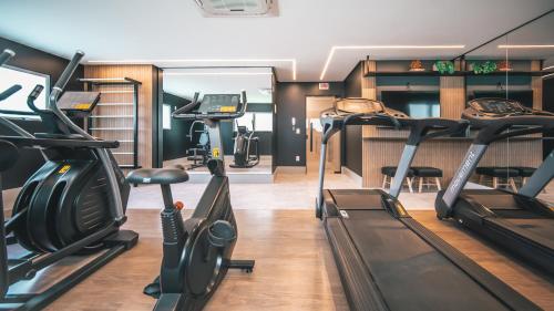 a gym with treadmills and elliptical machines at Hub Seu lar, fora de casa. in Criciúma