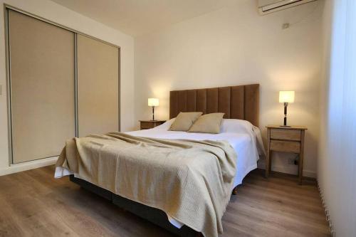 une chambre avec un grand lit blanc avec deux lampes dans l'établissement Departamento 3 ambientes., à Buenos Aires