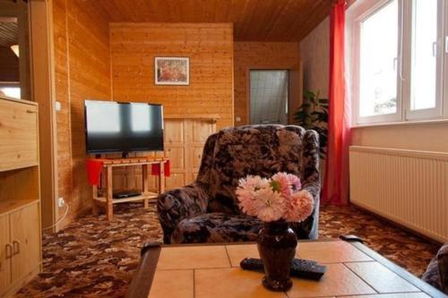 sala de estar con silla y TV en Ferienwohnung für 4 Personen ca 70 qm in Krummin, Ostseeküste Deutschland Usedom, en Krummin
