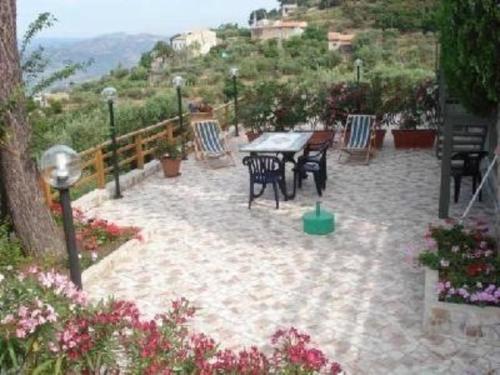 un patio con mesa, sillas y flores en Ferienwohnung für 2 Personen 2 Kinder ca 50 qm in Gioiosa Marea, Sizilien Nordküste von Sizilien, en Gioiosa Marea