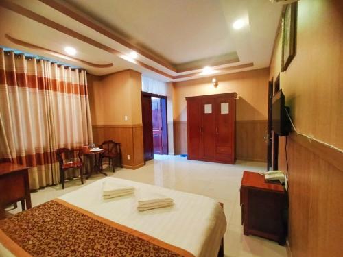 a hotel room with a bed and a dining room at Quoc Dung Hotel in Rạch Giá