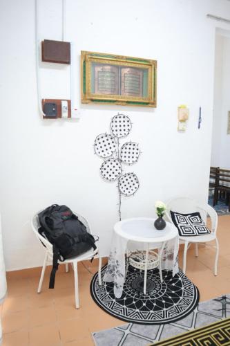 une chambre avec deux chaises et une table blanche dans l'établissement Singgahan Cinta Iris, à Kampong Gong Merbau