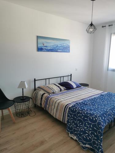 une chambre avec un lit avec une couette bleue dans l'établissement Maison familiale Andernos, à Andernos-les-Bains