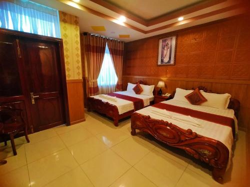 Una cama o camas en una habitación de Quoc Dung Hotel