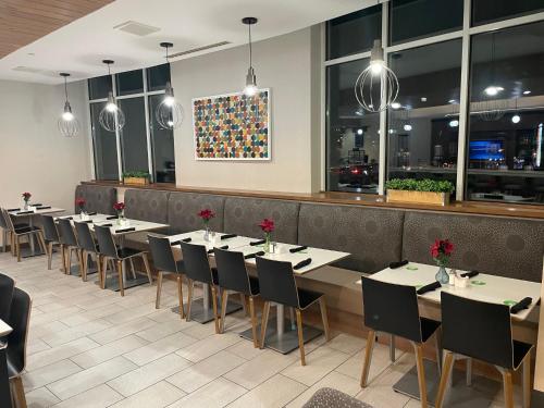 a row of tables and chairs in a restaurant at Holiday Inn Atlanta-Gas South Arena Area by IHG in Duluth