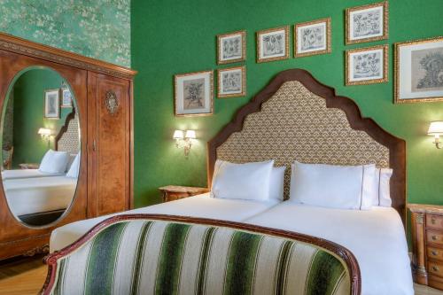 a bedroom with a bed and a large mirror at Hotel Palacio del Retiro, Autograph Collection in Madrid