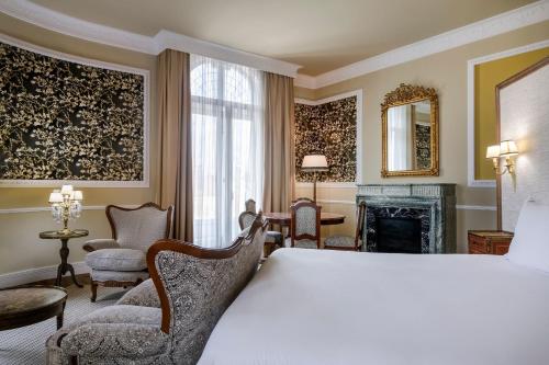 a hotel room with a bed and a fireplace at Hotel Palacio del Retiro, Autograph Collection in Madrid