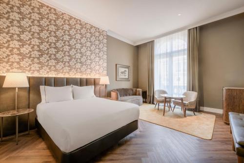 a hotel room with a bed and a table at Hotel Palacio del Retiro, Autograph Collection in Madrid