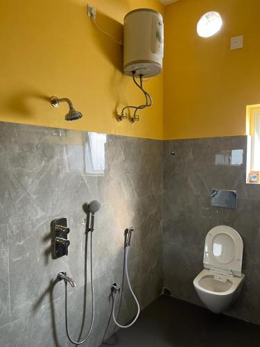 a bathroom with a shower and a toilet and a light at THE BROOME GURAP in Jāmpur