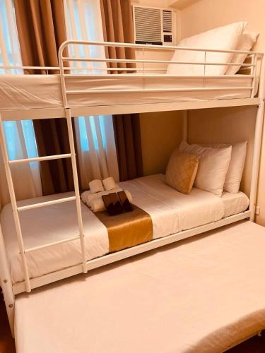a bedroom with two bunk beds with a couch at Condo in Davao City Near Airport (Seamaster Staycation II) in Davao City