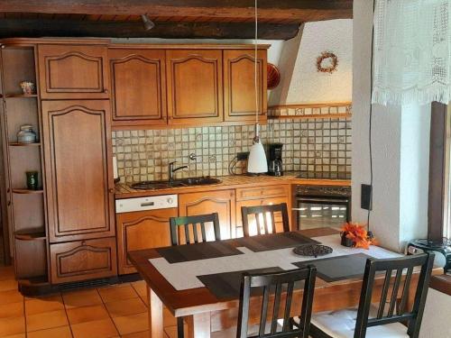 a kitchen with wooden cabinets and a table with chairs at Ferienwohnung in Horben mit Großem Garten in Horben