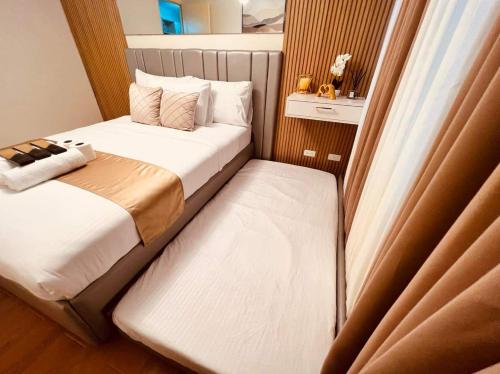 a small bedroom with two beds and a window at Condo in Davao City Near Airport (Seamaster Staycation II) in Davao City