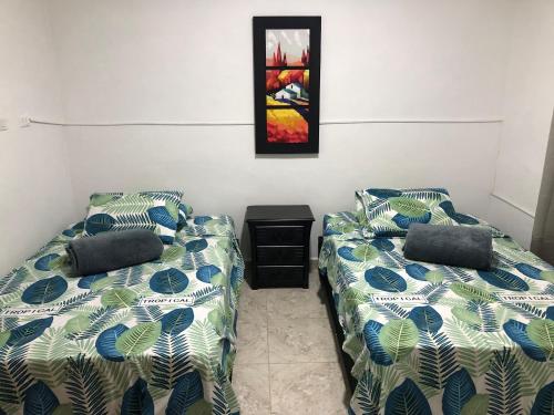 Zimmer mit 2 Betten und einem Bild an der Wand in der Unterkunft OLIVA´S HOUSE in Jardin