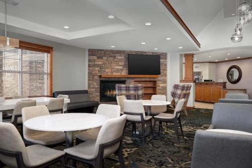 a waiting room with tables and chairs and a fireplace at Residence Inn by Marriott San Bernardino in San Bernardino