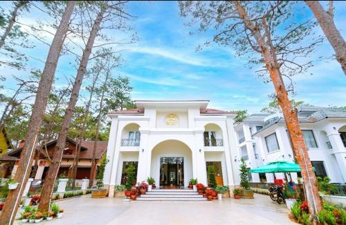 Vân Dương hotel في Kon Von Kla: مبنى ابيض عليه ساعه