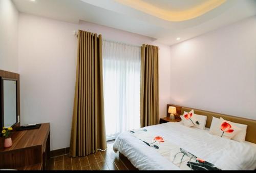 a bedroom with a bed and a window with curtains at Vân Dương hotel in Kon Von Kla